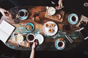 person-sitting-near-table-with-teacups-and-plates-2074130